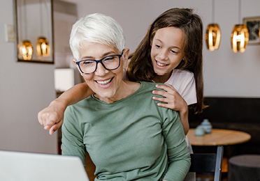 Frau mit Enkelin am Laptop informiert sich über Kreon im Zusammenhang mit EPI
